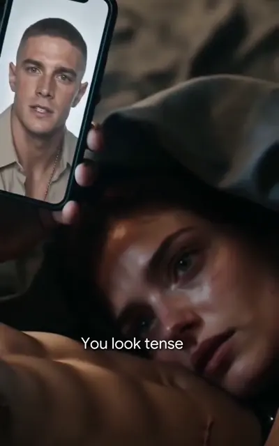 Noah shirtless with a dog tag chain by the window