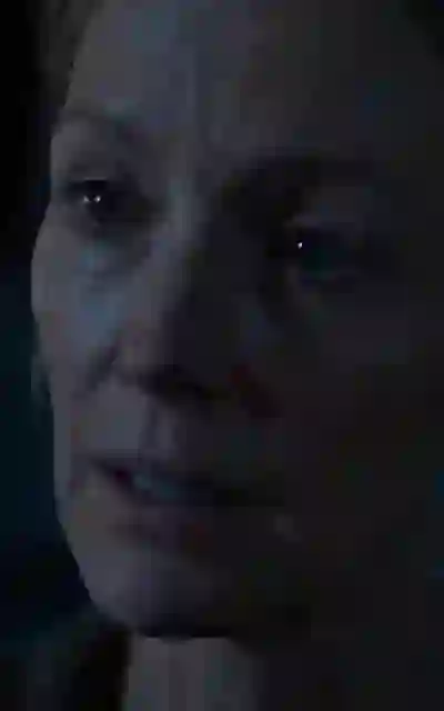 The mother speaking in the dim cabin room