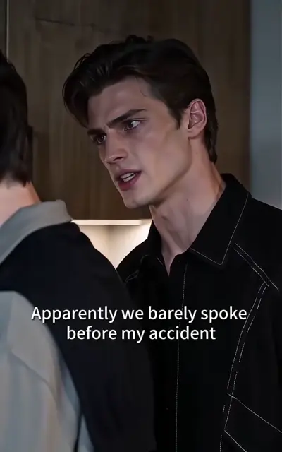 A young man in a half-zipped jacket looks aside