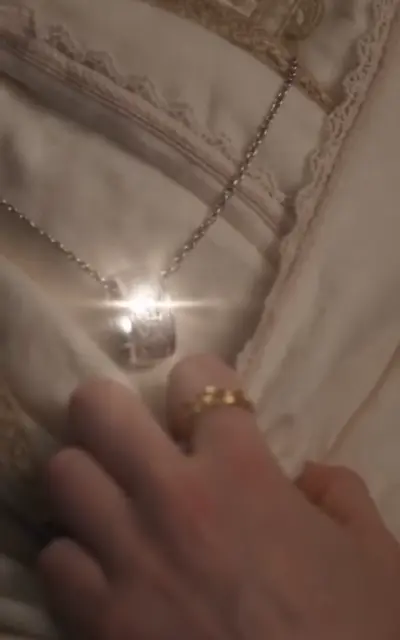 The glowing Griffin Crest pendant held in a hand