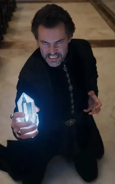 The kneeling noble raises a glowing crystal in black robes