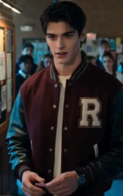 Dominic in a letterman jacket standing in a hallway
