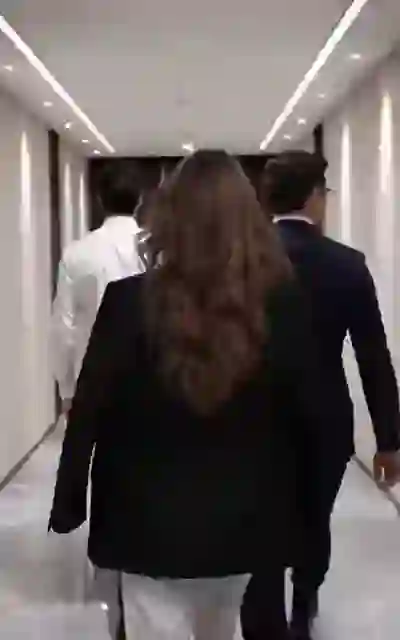 Mia walking the corridor beside him