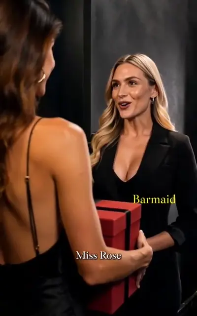 Two women talk at the party, one holding a red gift box