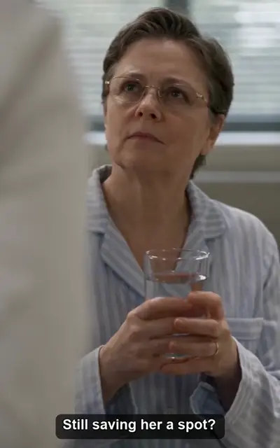 Professor Owen holding a glass in an office