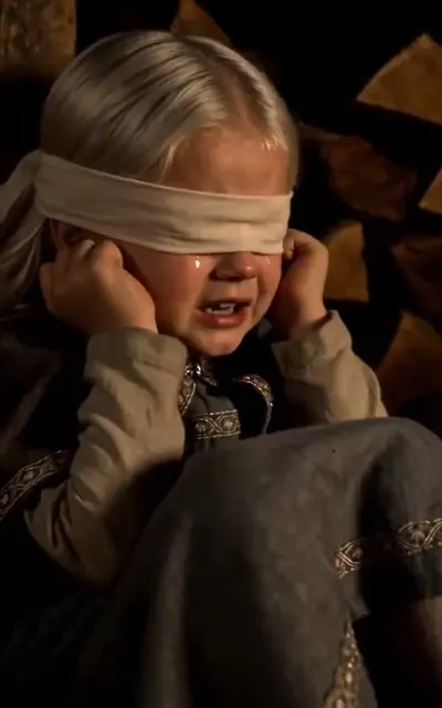 The blindfolded child crying by the firewood