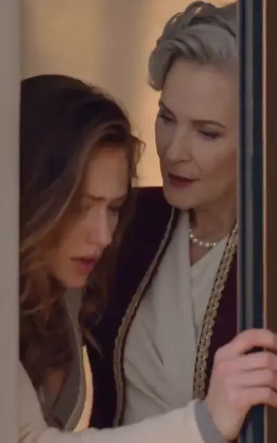 The grey-haired elder corners the wife by the door