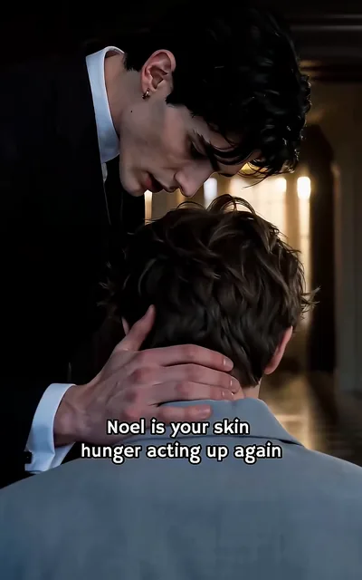 Adrian holds Noel's jaw in a dark hallway