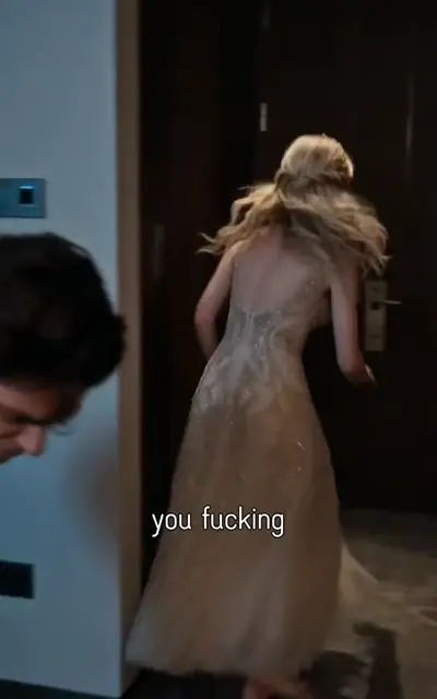 A blonde woman in a gown at a doorway