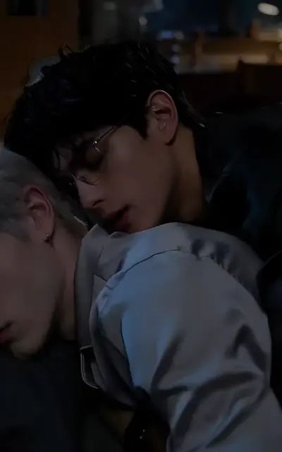 The two roommates lean close in a dark bedroom at night