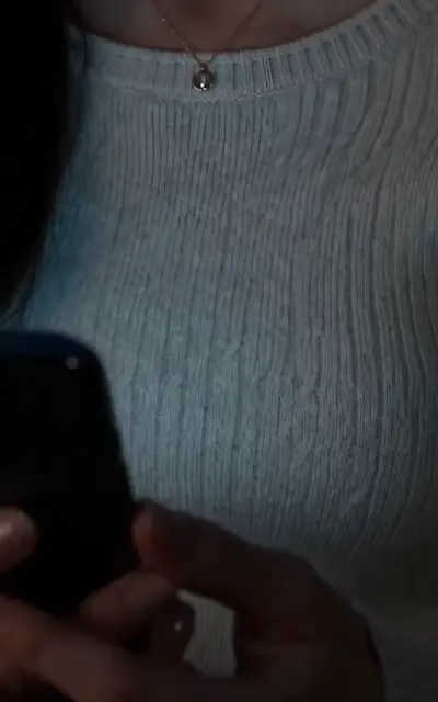 Olivia holding her phone in the dim living room