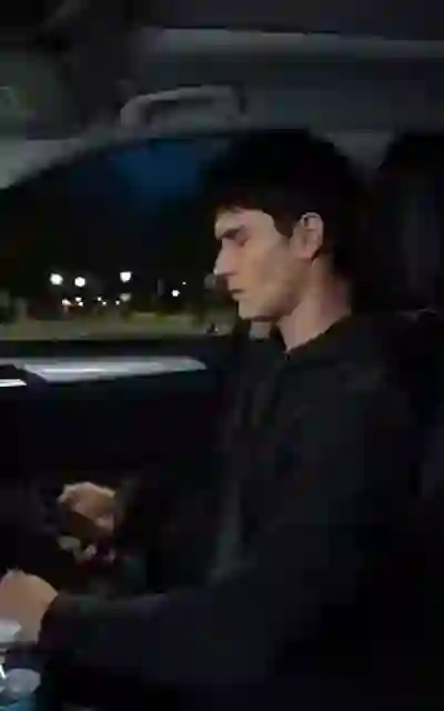 The new student seated in the car at night