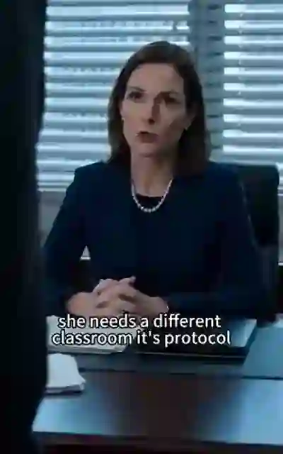 The teacher seated at the staff-room desk